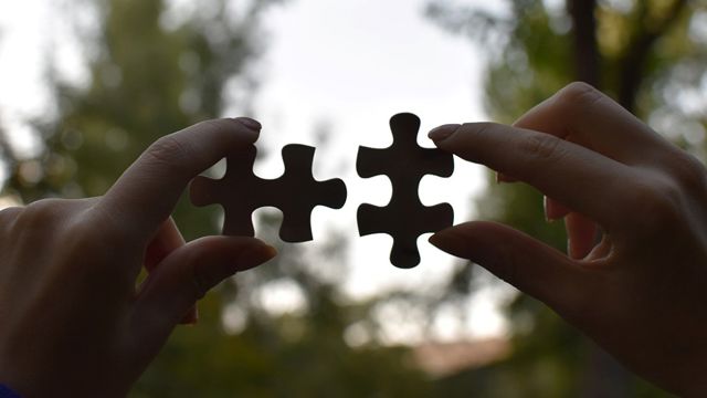 Hender som setter sammen puslespillbrikker
